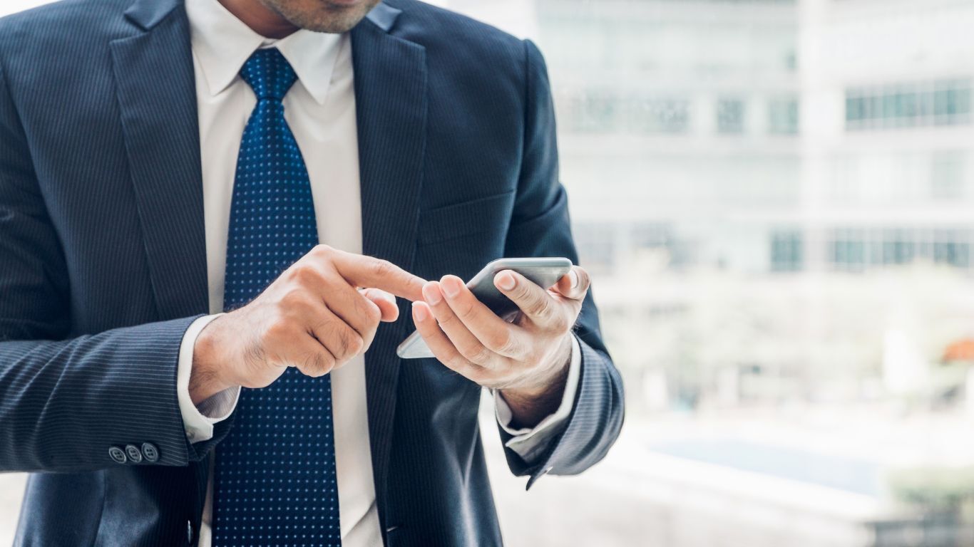 Contractor using a smartphone to access connected business systems and keep job information aligned.
