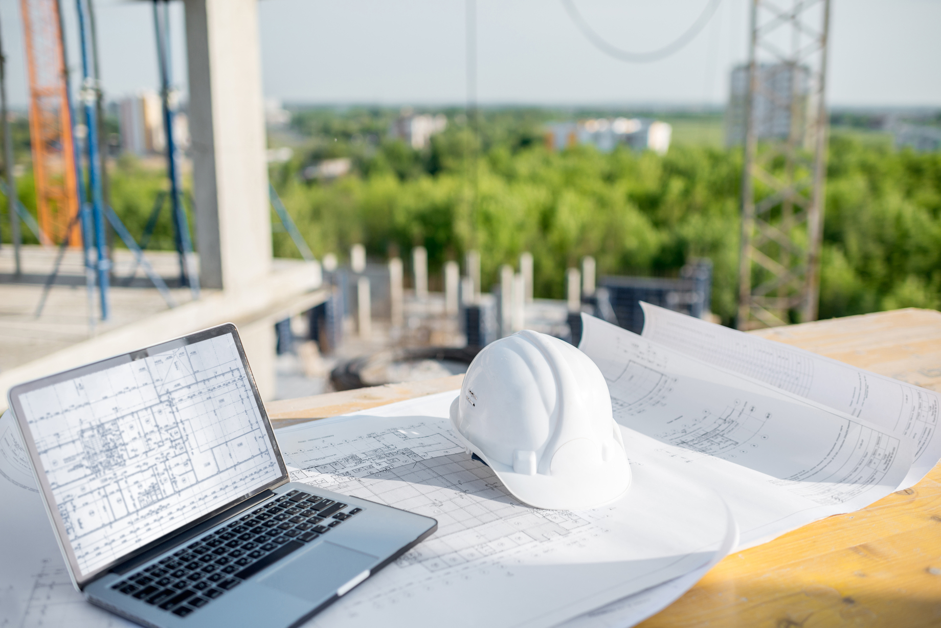 Hard hat, laptop and blueprints for construction software selection