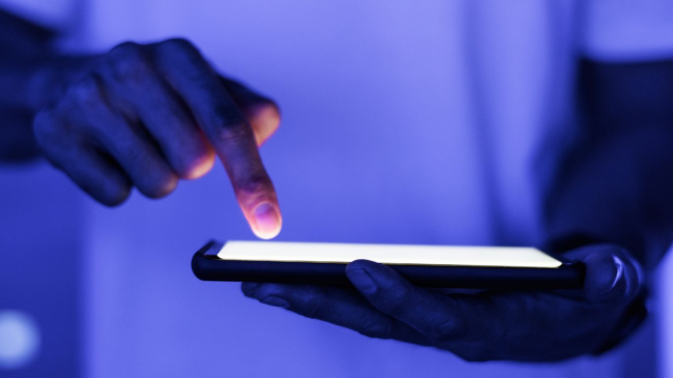 Person tapping a smartphone, representing CRM notifications that keep contractor teams and homeowners aligned.