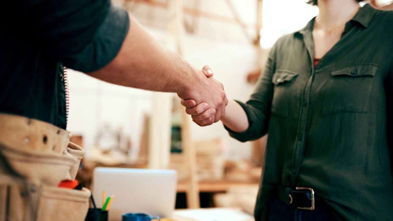 Contractor and customer shaking hands after a service visit, representing clear communication and trust.