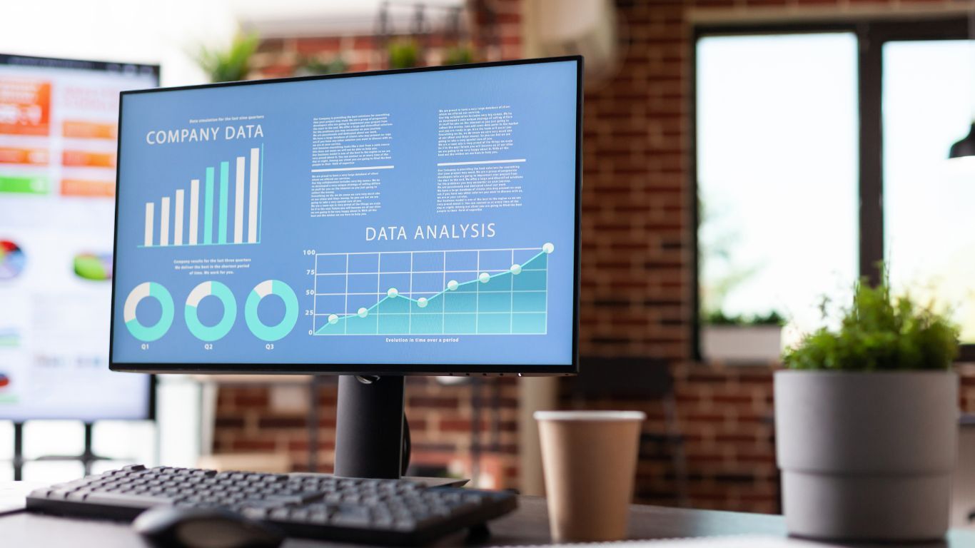 Contractor reporting dashboard on an office monitor showing charts used to identify business performance trends.