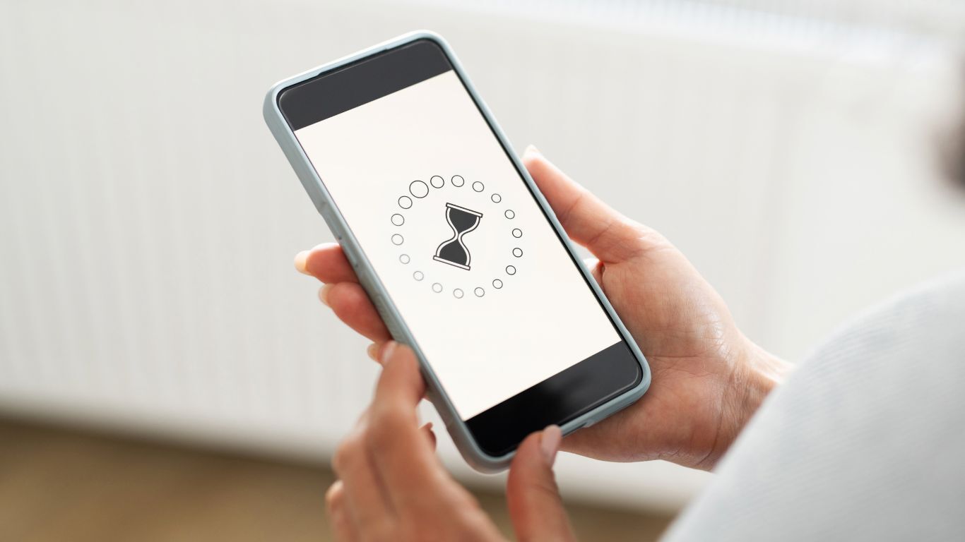 Person holding a smartphone with a loading icon, representing mobile access to a contractor customer portal.