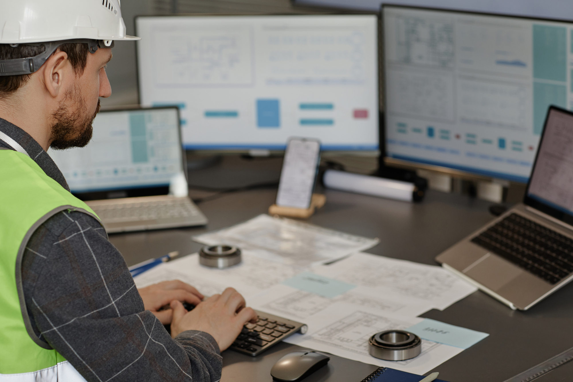 Male Engineer Wearing Hardhat in Office and Using Contractor Dashboard
